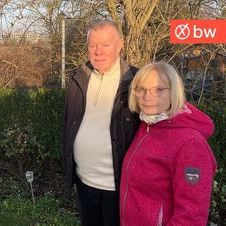 Jürgen und Elisabeth Wolf stehen in ihrem Garten und im Hintergrund sieht man das Gewerbegebiet von Weilimdorf, wo die neue LEA entstehen soll.