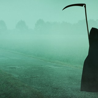 Der Tod, in Gestalt eines Sensemann, steht allein in einer weiten, nebeligen Landschaft
