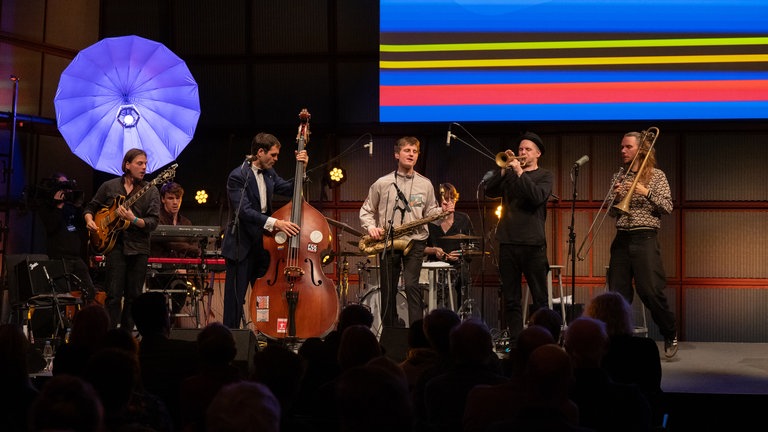 Ihrem wilden Sound zwischen Jazz, Funk, Balkan und Punk bezeichen sie selbst als "Junk"