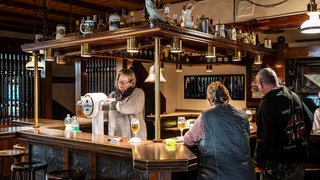 An der Bar einer urigen Kneipe wird Bier ausgeschenkt