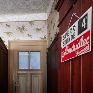 An einer Wand in Schankraum  einer Kneipe hängt ein Schild mit der Aufschrift: Sperrstunde 4h