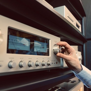 Eine Hand dreht an einem Radioregler