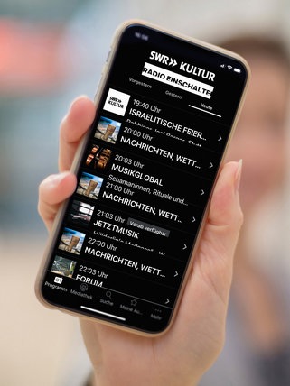 Eine Hand hält ein Smartphone mit der Programmübersicht in der SWR Kultur Radio App