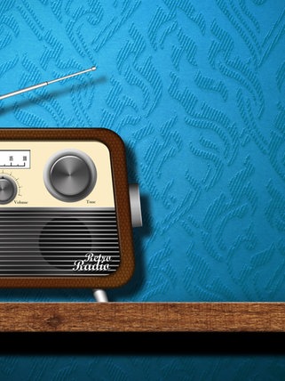 Ein altmodisches Radio mit Antenne steht auf einem Holztisch vor einer blauen Strukturtapete
