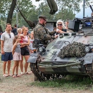 Offener Stützpunkt Hohe Düne in Warnemünde: Eine Familie schaut sich einen Panzer an, ein Bundeswehrsoldat erklärt: Bundesverteidigungsminister Boris Pistorius wünscht sich einen Mentalitätswechsel bei den Deutschen. Sie sollen "kriegstüchtig" werden. Und tatsächlich: Angesichts des russischen Kriegs floriert die Rüstungsindustrie, die Bundeswehr erfährt eine neue Wertschätzung.