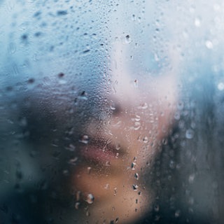 Junge verschwommen hinter einer regennassen Fensterscheibe: Kinder, die sexuelle Gewalt in der Familie erleben, sind ihr oft schutzlos ausgeliefert. Umso wichtiger ist, dass das Umfeld genau hinschaut und mutig handelt.IMAGO  Addictive Stock