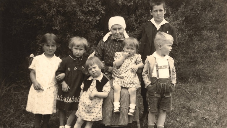 Eine Mutter mit ihren 6 Kindern im Deutschland der späten 1930er-Jahre: Im Nationalsozialismus ist erste Staatsbürgerpflicht der Frau das Gebären künftiger Soldaten. Mütterschulen professionalisieren den Hausfrauenberuf.