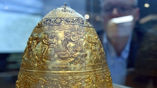 Goldene Tiara in einer Vitrine: Josef Mühlenbrock, damaliger Direktor des LWL Museums, schaut sich 2018 die Fälschung der Tiara des Saitaphernes in der Ausstellung "Irrtümer & Fälschungen der Archäologie" an.
