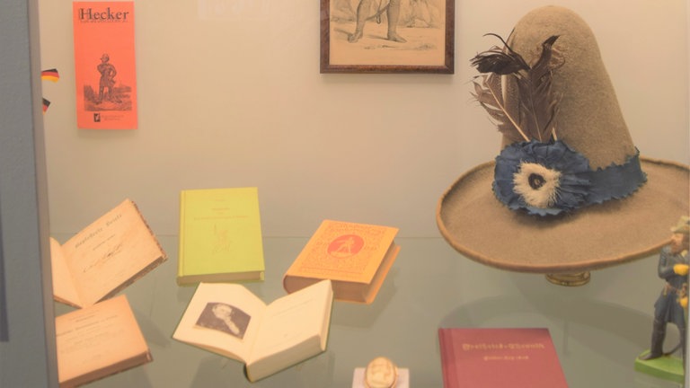 Badische Revolution 1848: "Hecker-Vitrine" in der Ausstellung "Jetzt machen wir Republik!" im Rosgarten Museum Konstanz mit typischen Memorabilia, die nach Friedrich Heckers Emigration im Südwesten als Souvenirs entstanden: Hüte, Tabakspfeifen-Köpfe, Bücher usw. 