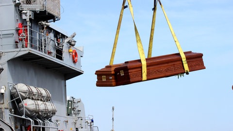 Särge der Flüchtlinge, die beim Unglück am 3. Oktober 2013 vor Lampedusa ums Leben kamen, werden im Hafen auf ein Schiff der italienischen Marine verfrachtet. Das Boot war vor der italienischen Insel mit hunderten Flüchtenden an Bod gesunken, 366 Menschen starben. Das Entsetzen in Europa war groß. Der Papst reiste auf die Insel und rief zu mehr Solidarität mit den Hilfesuchenden auf. Geschehen ist seither das Gegenteil. 