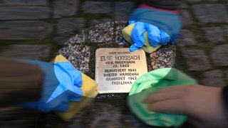 Drei Kinderhände putzen einen Stolperstein in der Lübecker Straße in Magdeburg: Seit Jahrzehnten behandeln Schulen den Holocaust im Unterricht. Trotzdem ist "Jude" auf Schulhöfen als Schimpfwort zu hören und Jugendliche provozieren mit Wörtern wie "vergasen". Viele Lehrkräfte fühlen sich in solchen Situationen überfordert. 