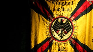 Das Reichsbanner "Schwarz-Rot-Gold" von 1924: In der Weimarer Republik fanden sich am 22. Februar 1924 Sozialdemokraten, Mitglieder der Zentrumspartei, der liberalen DDP und Gewerkschafter zusammen zum "Reichsbanner Schwarz-Rot-Gold". Dessen Hauptaufgabe: die Demokratie gegen Nationalsozialisten, Kommunisten und Monarchisten zu verteidigen.