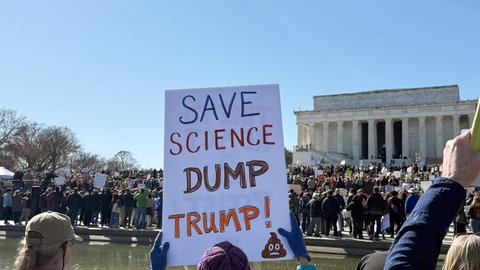 Ein Schild mit der Aufschrift «Save Science - Dump Trump!» (Rettet die Wissenschaft - Weg mit Trump!) ist bei einer Kundgebung von Wissenschaftlern und Forschern gegen Trumps Politik von Kürzungen bei den Etats der Forschung und Stellenstreichungen am Lincoln Memorial zu sehen.