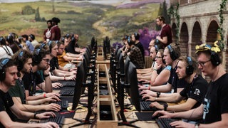 Besucher der Gamescom testen 2025 das Computerspiel "Anno 117" des deutschen Entwicklerstudios Ubisoft Blue Byte: Die Games-Branche kriselt, deutsche Studios hinken bei Top-Spielen hinterher. Finanzierung und Programmierung sind eine Herausforderung.