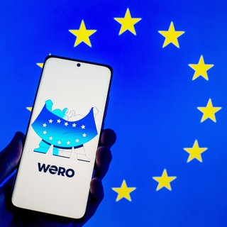 Screenshot der Wero-App mit EU-Flagge: Eine europäische Echtzeit-Zahlungslösung, die Überweisungen innerhalb von 10 Sekunden per Handynummer ermöglicht, wurde von der European Payments Initiative entwickelt als Alternative zu PayPal