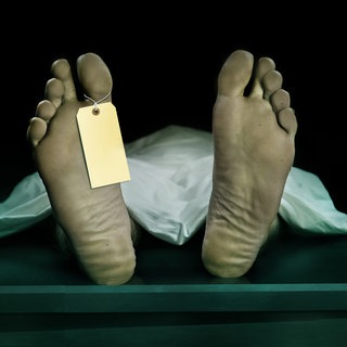 Fußsohlen eines liegenden Toten, an einem Zeh hängt ein Zettel (Symbolbild): Kaum ein medizinischer Bereich ist so fehleranfällig wie die Leichenschau: Ärztinnen und Ärzte sind oft schlecht ausgebildet und übersehen immer wieder Verletzungen. 