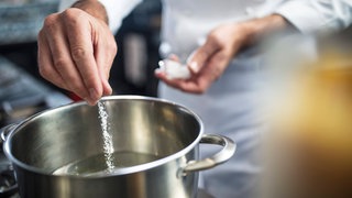 Koch gibt Salz in einen Topf mit Wasser: Kocht gesalzenes Wasser schneller?