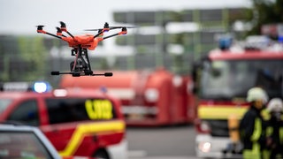 Eine Drohne fliegt vor Einsatzfahrzeugen bei einem Test-Einsatz. Das Deutsche Rettungsrobotik-Zentrum (DRZ) stellt einen neuartigen Robotikleitwagen für Katastropheneinsätze vor. 