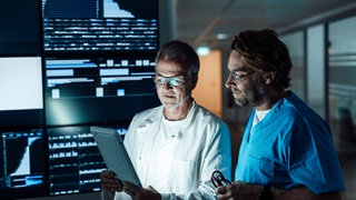 Symbolfoto: Medizinisches Fachpersonal analysiert Daten auf einem Tablet 