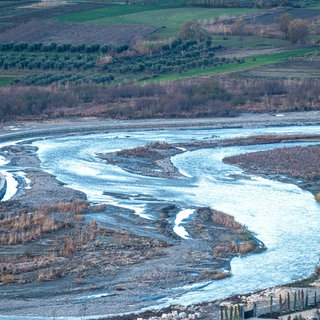 Symbolbild: Sich schlängelnder, halb ausgetrockneter und schlammiger Fluss.