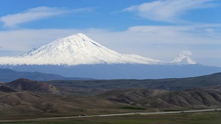 Schneebedeckte Berge unter klarem blauen Himmel mit weitläufiger Landschaft im Vordergrund, großer und kleiner Ararat