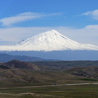 Schneebedeckte Berge unter klarem blauen Himmel mit weitläufiger Landschaft im Vordergrund, großer und kleiner Ararat