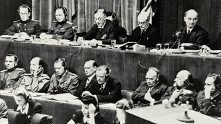 Urteilsverkündung am 1. Oktober 1946 beim Nürnberger Kriegsverbrecherprozeß vor dem alliierten Militärtribunal. Die Richterbank im Justizpalast während der Verlesung der Urteilsbegründung. V. l. n. r.: Wolchkow, Nikitschenko (UdSSR), Birkett, Lawrence (GB) und Biddle (USA)