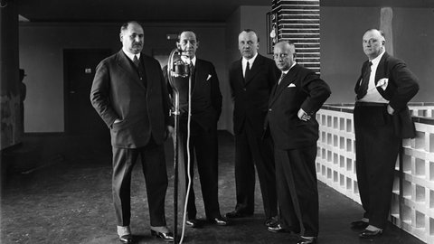 Einweihung des "Haus des Rundfunks": (v.l.n.r.) Staatssekretär Hans Bredow, Funkintendant Hans Flesch, Alfred Braun und Direktor Knöpkke, die Leiter des Berliner bzw. deutschen Funkwesens, vor einem Mikrofon. (Foto 1931)