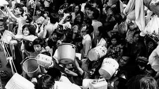 Vietnamesische "Boat People" an Bord des Flüchtlingsschiffs "Tung An" halten den Besatzungsmitgliedern eines Schiffes der philippinischen Marine, das am 21. Februar 1979 mit frischem Trinkwasser anlegte, Eimer und Kanister hin. Seit acht Wochen sitzen die Flüchtlinge an Bord der Tung An in der Bucht von Manila fest.