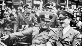 Adolf Hitler und der italienische Diktator Benito Mussolini (links) gut gelaunt im offenen Wagen am 29. September 1938 in München anlässlich der Konferenz zur tschechischen Krise. Hitler hatte Mussolini am Bahnhof abgeholt und zusammen fuhren sie im Auto weiter zum Ort der Münchner Konferenz, dem "Braunen Haus".