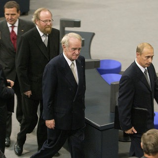 Nach seiner Rede im Deutschen Bundestag 2001 geht der russische Präsident Wladimir Putin (rechts) durch den Plenarsaal im Reichstagsgebäude, gefolgt von Bundespräsident Johannes Rau, Bundestagspräsident Wolfgang Thierse und Bundeskanzler Gerhard Schröder