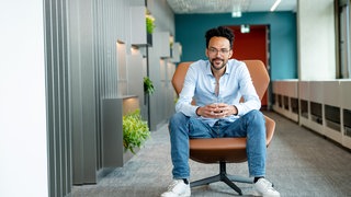 Mann in sitzender Position mit Kaffeebecher