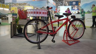Ein rotes Fahrrad mit einer Drehscheibe auf dem Vorderrad.