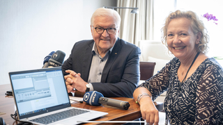 Evi Seibert und Bundespräsident Steinmeier mit Laptop und Mikrofon am Tisch