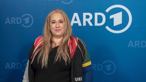 Idil Baydar vor blauem ARD-Hintergrund