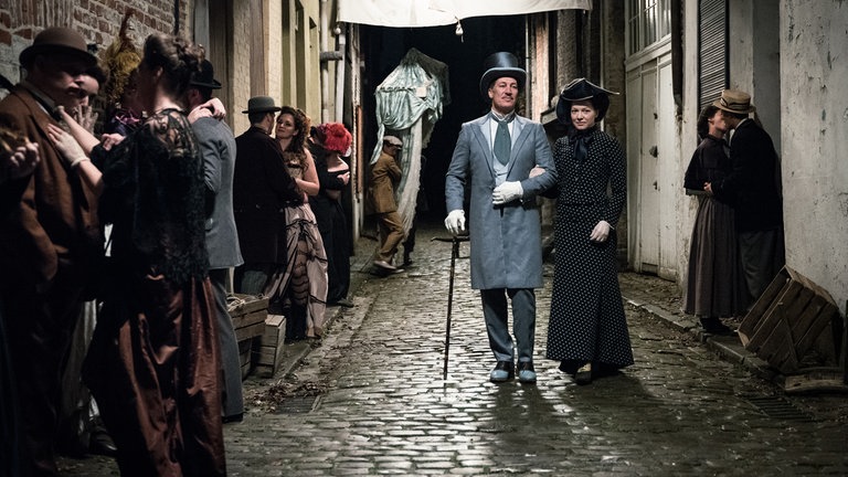 Macheath (Tobias Moretti) und Polly Peachum (Hannah Herzsprung) kommen sich in den Straßen Londons näher. © SWRWild Bunch GermanyStephan Pick