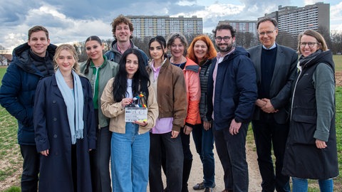 Am Set des Kinofilms „Drei Kameradinnen“: Kameramann Mortimer Hochberg  Brikena Ray (Rolle Hani)  Manal Raga a Sabit (Rolle Saya)   Stephan Henz, DCM  Regisseurin Milena Aboyan  Bayan Layla (Rolle Kasih)  Stefanie Groß (SWR)  Gabriele Mast (SWR)  Ben Zerhau (Produzent)  Carl Bergengruen (MFG)  Sophia Aldenhoven (Produzentin).