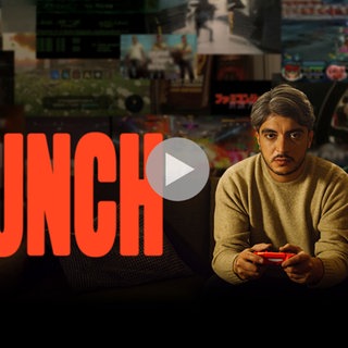 "Crunch"-Keyvisual zeigt Host Khesrau Behroz mit Videospiel-Controller auf dem Sofa sitzend. Auf dem Bild befindet sich ein Playbutton.