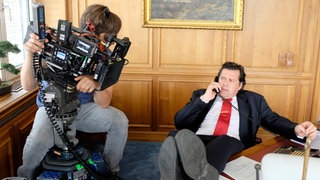 Hans-Jochen Wagner, der die Titelfigur Manfred Brenner spielt. Im Hintergrund: Kameramann Michael Schreitel. © SWRBenoit Linder