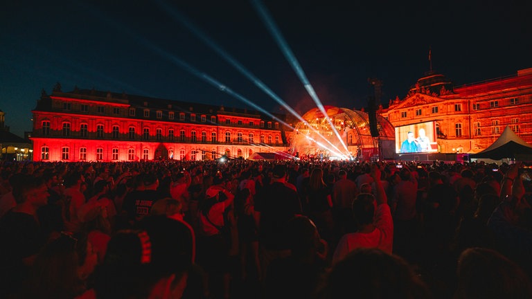 Neues Schloss mit Bühne und Publikum am Abend