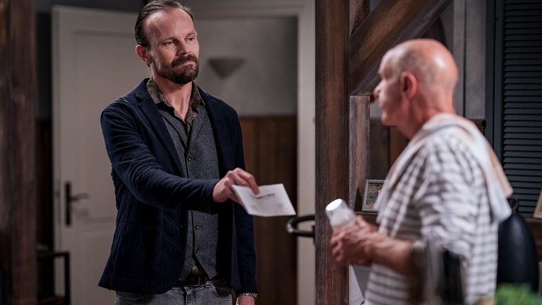 Constantin (Robert Besta) hält Heinz (Thomas Meinhardt) ein Stück Papier hin