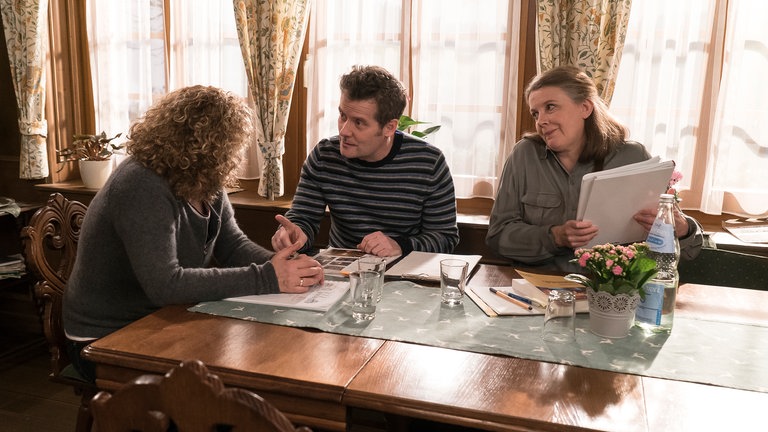 Bea, Markus und Evelyn besprechen sich im Wohnzimmer