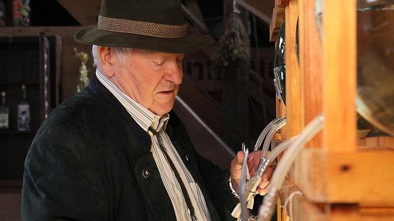 Zimmermanna lässt Schnaps aus einer großen Flasche laufen