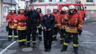 Die Feuerwehrmannschaft steht vor dem Feuerwehrhaus