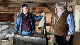 Toni hält Hermann in der Mühle einen alten Lappen hin