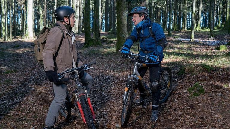 Sebastian und Sam mit ihren Fahrrädern im Wald