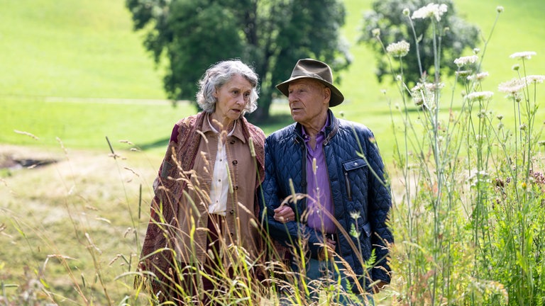 Franz (Edgar-M. Marcus) und Irene (Susanne Scholl) gehen auf der Wiese spazieren