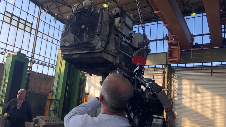 Ein Getriebe fliegt durch die Luft. In dem Spezialwerk für historische Schienenfahrzeuge werden immer mehrere Fahrzeuge gleichzeitig repariert. 