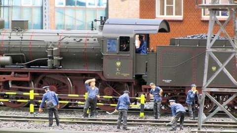 Figuren am Bahnübergang. An Figuren mangelt es nicht auf der Anlage, denn ein Mitglied gestaltet und gießt diese 6 cm großen Figuren selbst