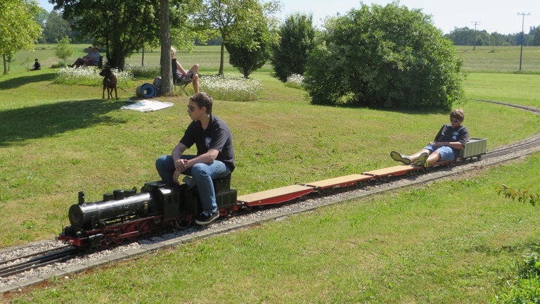 Diese beiden Jungs waren unermüdlich unterwegs. Endlich mal Eisenbahn fahren bis es dunkel wird. Während der eine für das Feuer im Kessel sorgt, ruht sich der andere eine Runde aus.